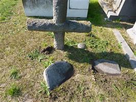 Kruis en vier halfbegraven grafstenen